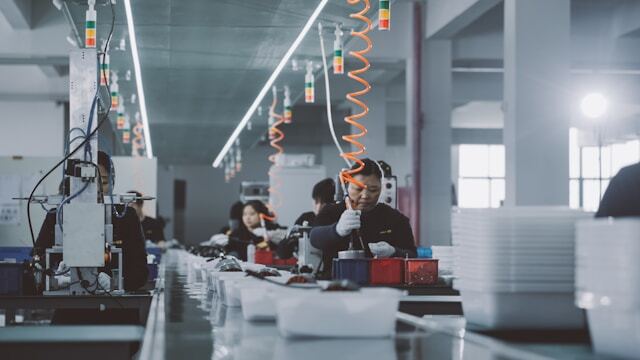 Team of workers collaborating on a factory floor in a manufacturing facility