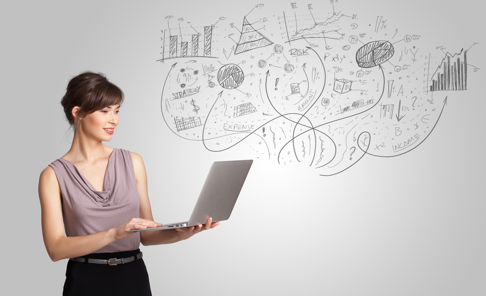 Woman holding a laptop with marketing and sales diagrams, representing outbound vs inbound sales strategy for B2B growth