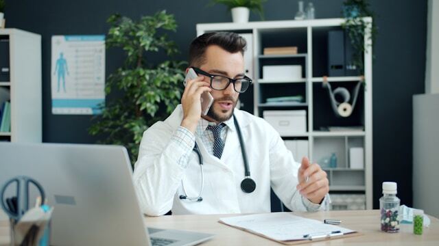 doctor on phone at desk in office